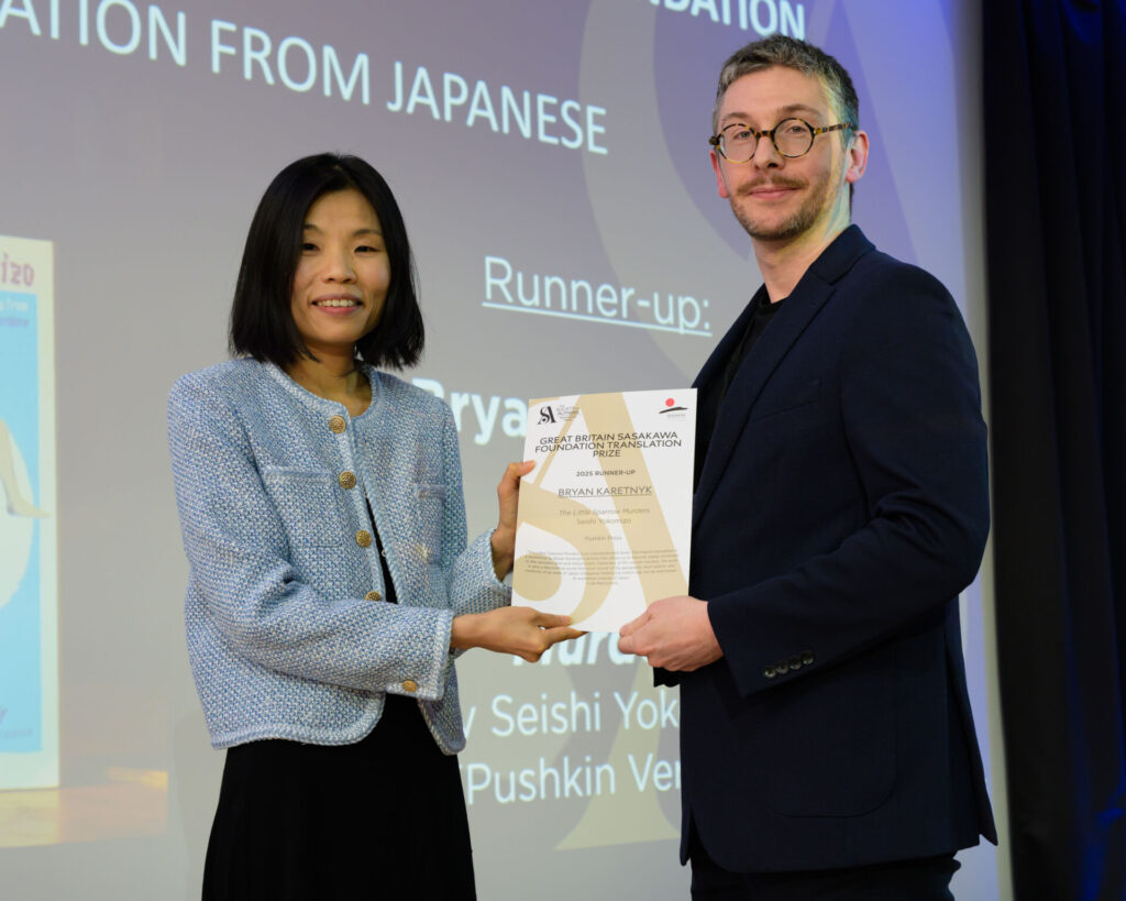 Bryan Karetnyk holding a certifcate with host Fiona Sze-Lorrain