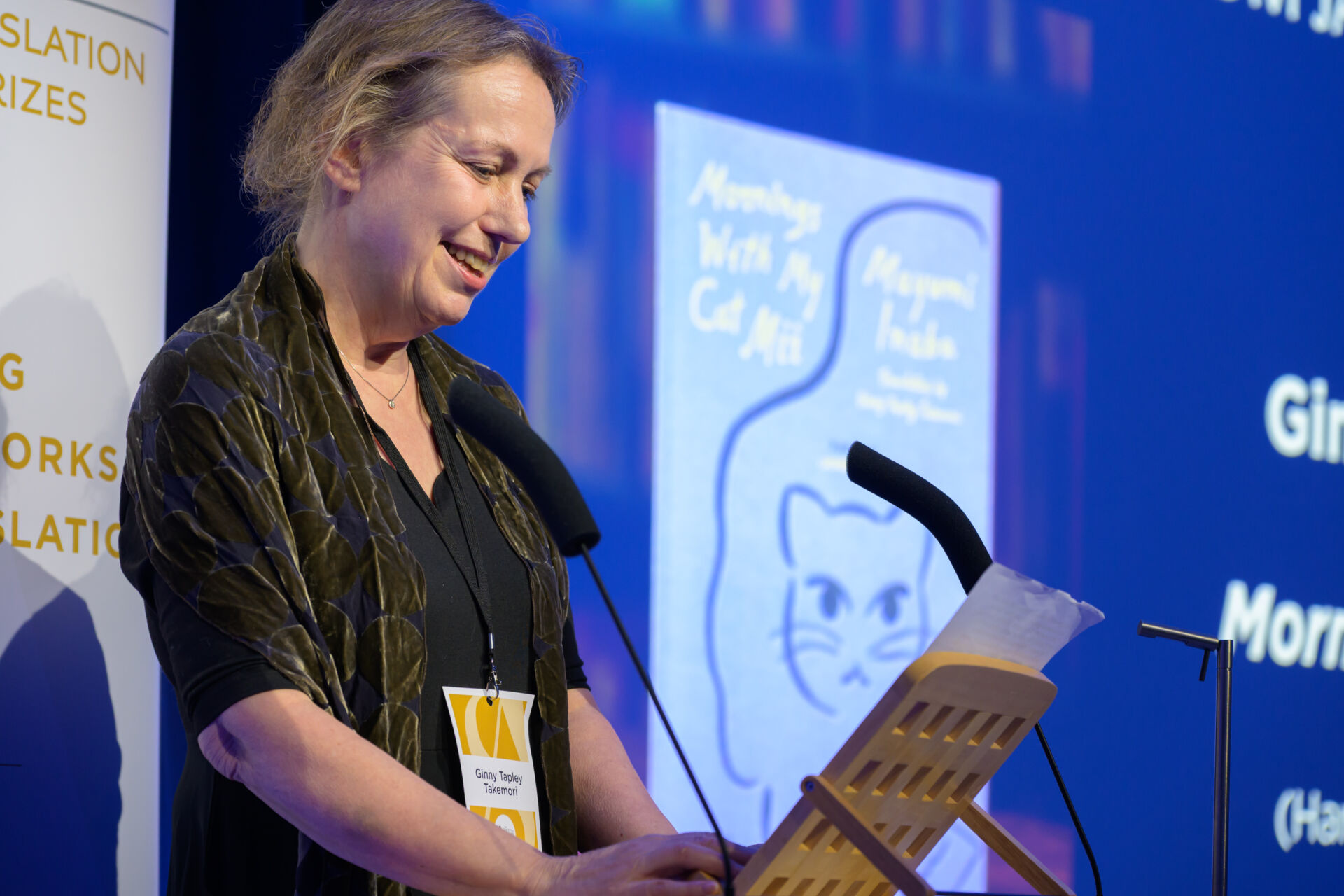 Ginny Tapley Takemori at the lectern doing a reading