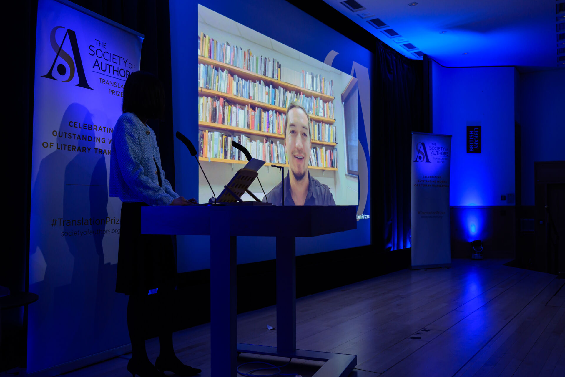 Jon Cho-Polizzi on a large screen on the stage