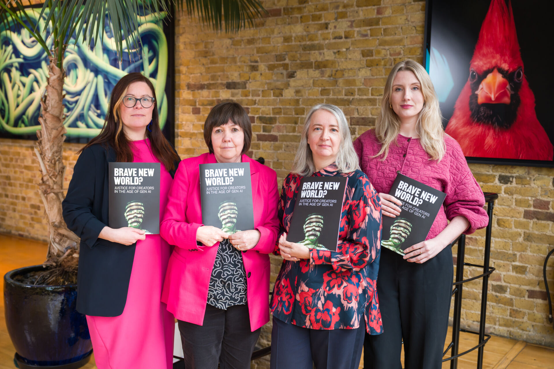 Four women standing in a group and holding copies of the Brave New World? report