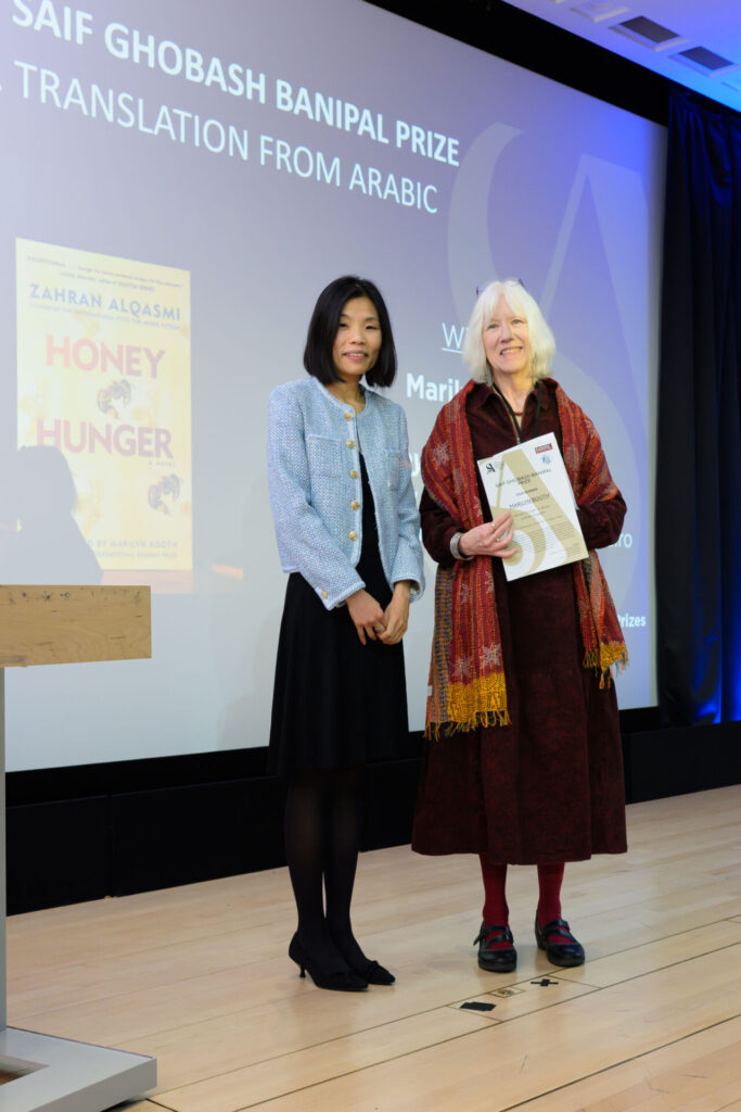 Marilyn Booth holding a certificate with Fiona Sze-Lorrain