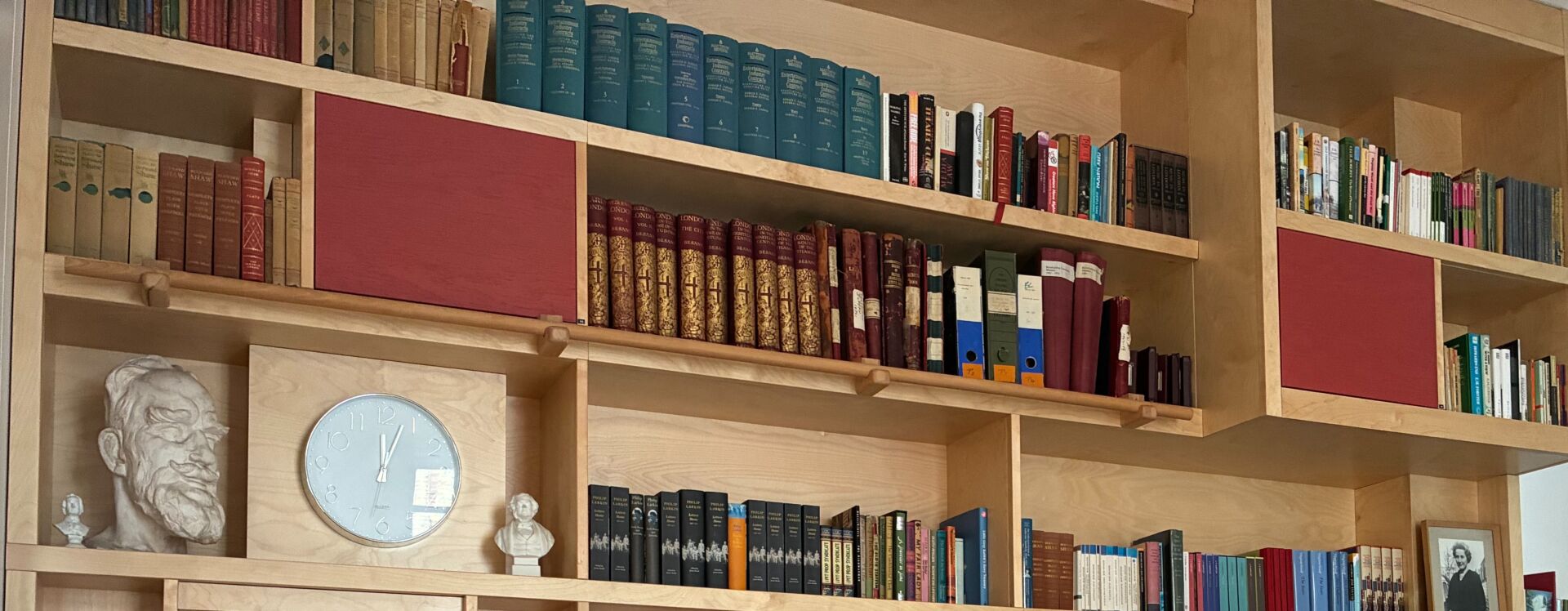 A shelf of old books and busts