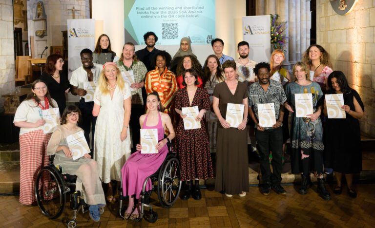 A group of people standing in front of a stage holding certificates