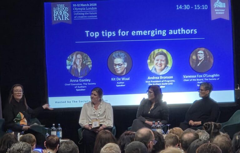 A panel of speakers in front of an audience. The screen behind them says Top tips for emerging authors.