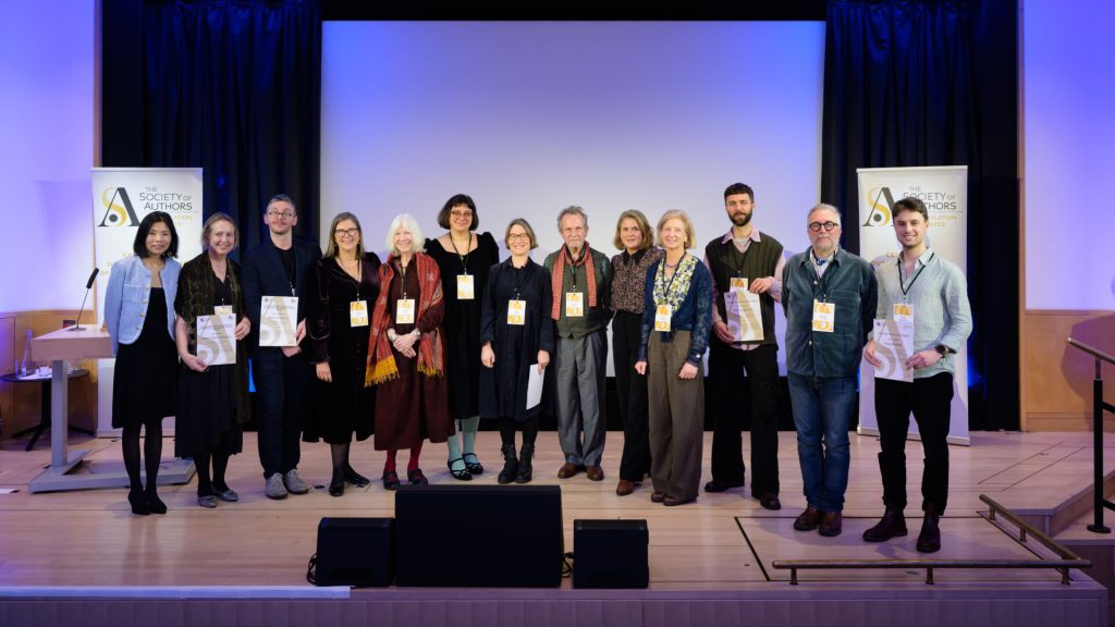 A group of people standing on a stage and holding certificates